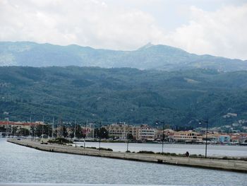 Scenic view of river by mountains against sky