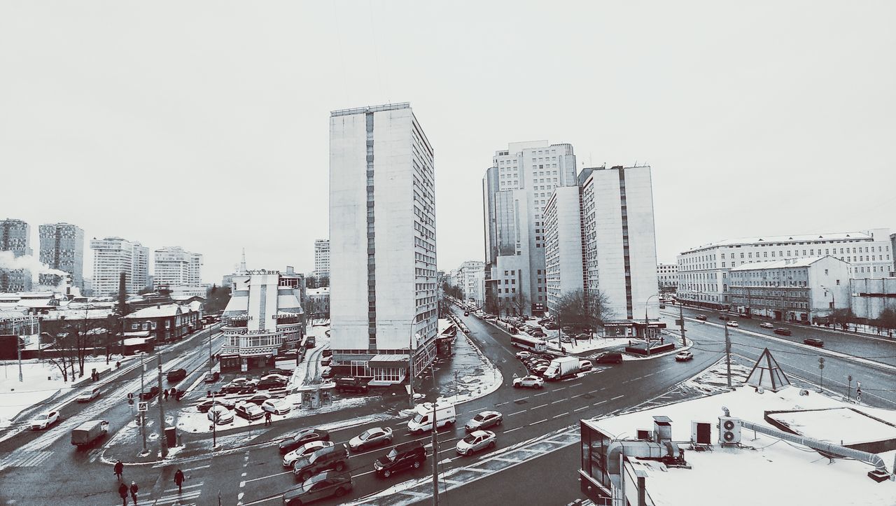 city, building exterior, architecture, built structure, skyscraper, cityscape, tower, development, outdoors, clear sky, day, urban skyline, cold temperature, snow, no people, sky