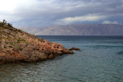 Scenic view of sea and mountains against sky