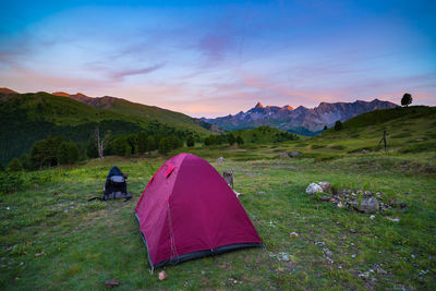 Tent on mountain against sky during sunset