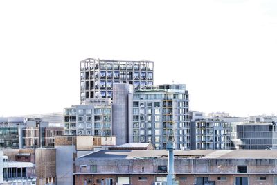 Buildings in city against clear sky