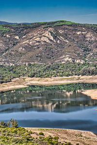 Scenic view of lake by mountain against sky