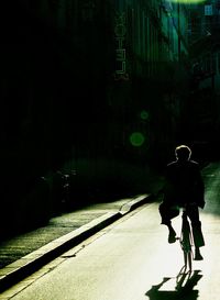 Rear view of man riding motorcycle on road