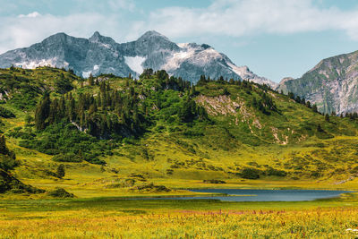 Scenic view of lake by mountains against sky