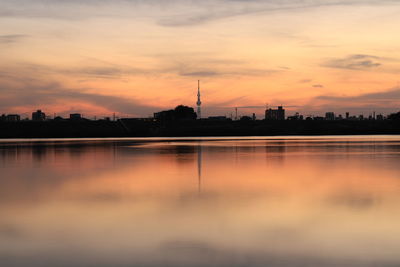 Scenic view of lake against orange sky