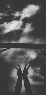 Silhouette person hand against sky