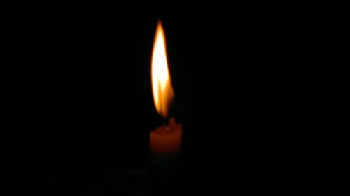 Close-up of burning candle in darkroom