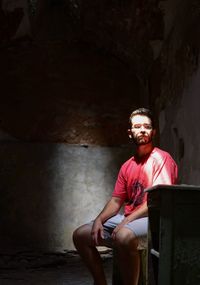 Thoughtful man sitting in darkroom