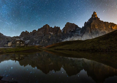 Scenic view of lake and mountains against sky at night