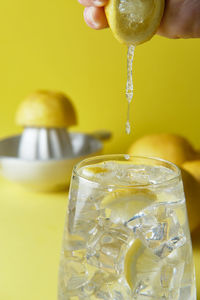 Squeezing lemon in a glass to make lemonade