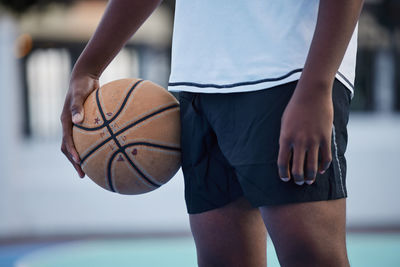 Midsection of woman playing basketball