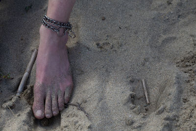 Low section of person on sand at beach