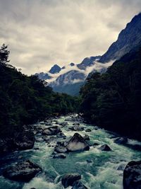 Scenic view of river amidst mountains against sky