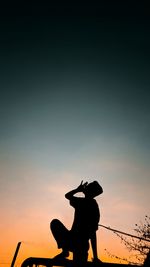 Silhouette man riding horse against sky during sunset