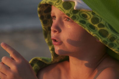 Close-up of cute wet boy looking away at beach