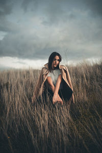 Young woman on field against sky