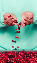 Woman holding cranberries in her hands, close up