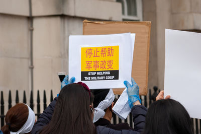 Rear view of people standing against wall