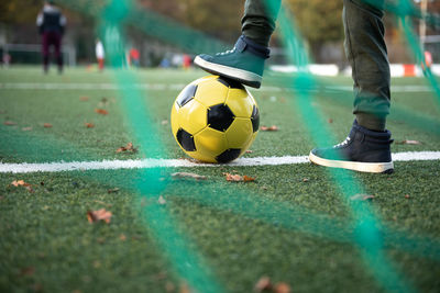 A little boy plays soccer with his father on the soccer field