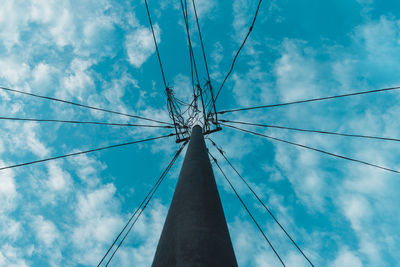 Low angle view of electricity pylon against blue sky