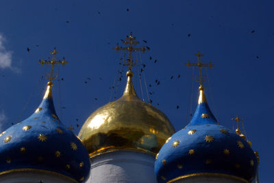 Close-up of cross against building against clear blue sky