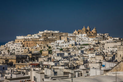 Buildings in town against blue sky