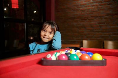 Portrait of smiling girl playing pool