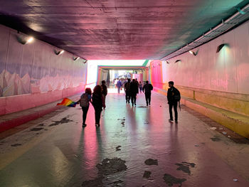 Rear view of people walking in subway tunnel