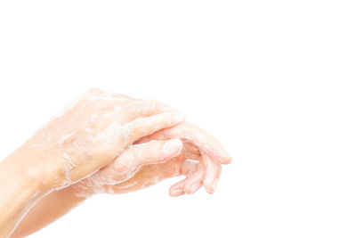 Close-up of woman holding water drops against white background