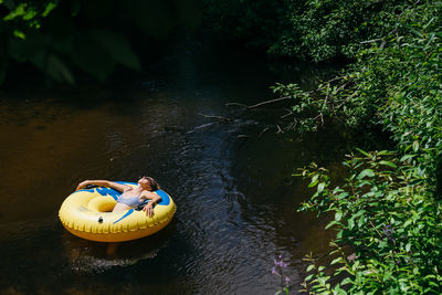 High angle view of people floating on river in forest