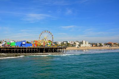 Amusement park rides on santa monica pier against sky