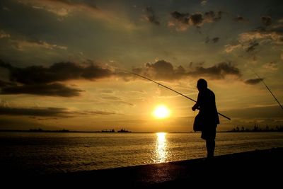 Silhouette of people on beach at sunset