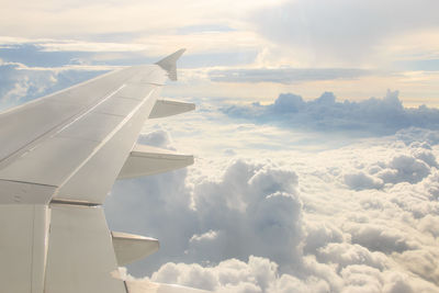 Cropped image of airplane flying over clouds