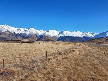 Scenic view of snowcapped mountains against clear blue sky