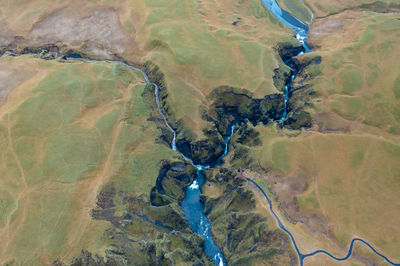 Winding blue riverbed flowing between rocks in iceland, natural amazing landscape. drone shot.