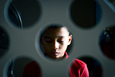 Boy seen through perforated metal