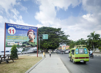 Cars on road against sky in city