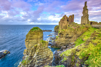 Rock formations by sea against sky