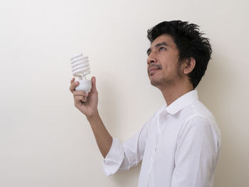 Young man looking away against white background