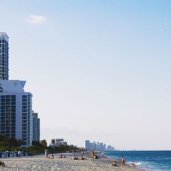 People on beach against clear sky