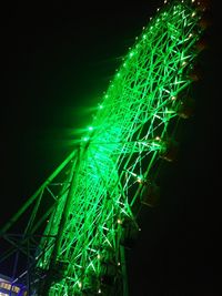 Low angle view of illuminated ferris wheel against sky at night