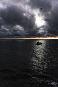 Scenic view of sea against cloudy sky during sunset