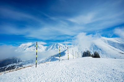 People skiing on snow covered mountain against sky