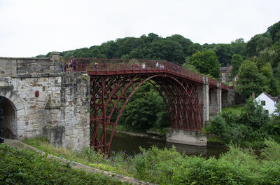 Arch bridge over river against sky