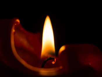 Close-up of lit candle in the dark