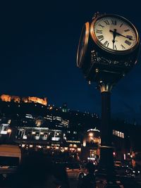 Illuminated clock tower at night