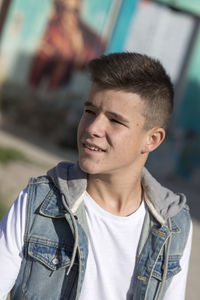 Close-up of thoughtful teenage boy standing outdoors