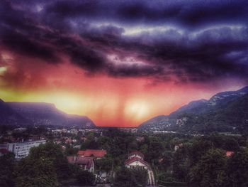 Aerial view of illuminated cityscape against dramatic sky