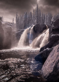 Scenic view of waterfall against sky