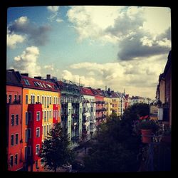 Buildings in city against cloudy sky